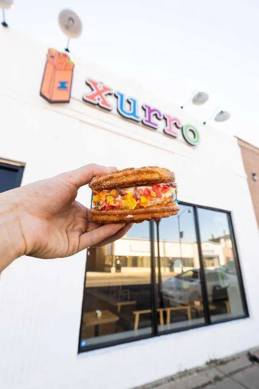 Churro ice cream sandwich in front of the Xurro storefront